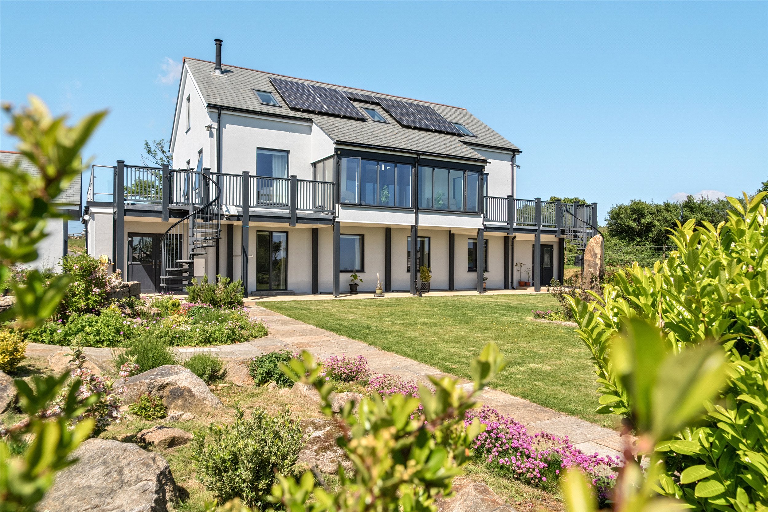 Solar panels on a contemporary home surrounded by greenery